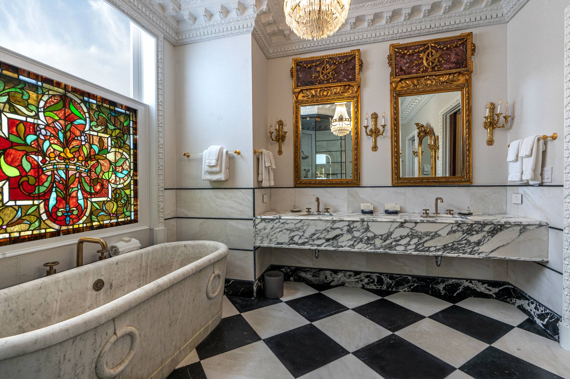 a bathroom with marble tub and mirrors
